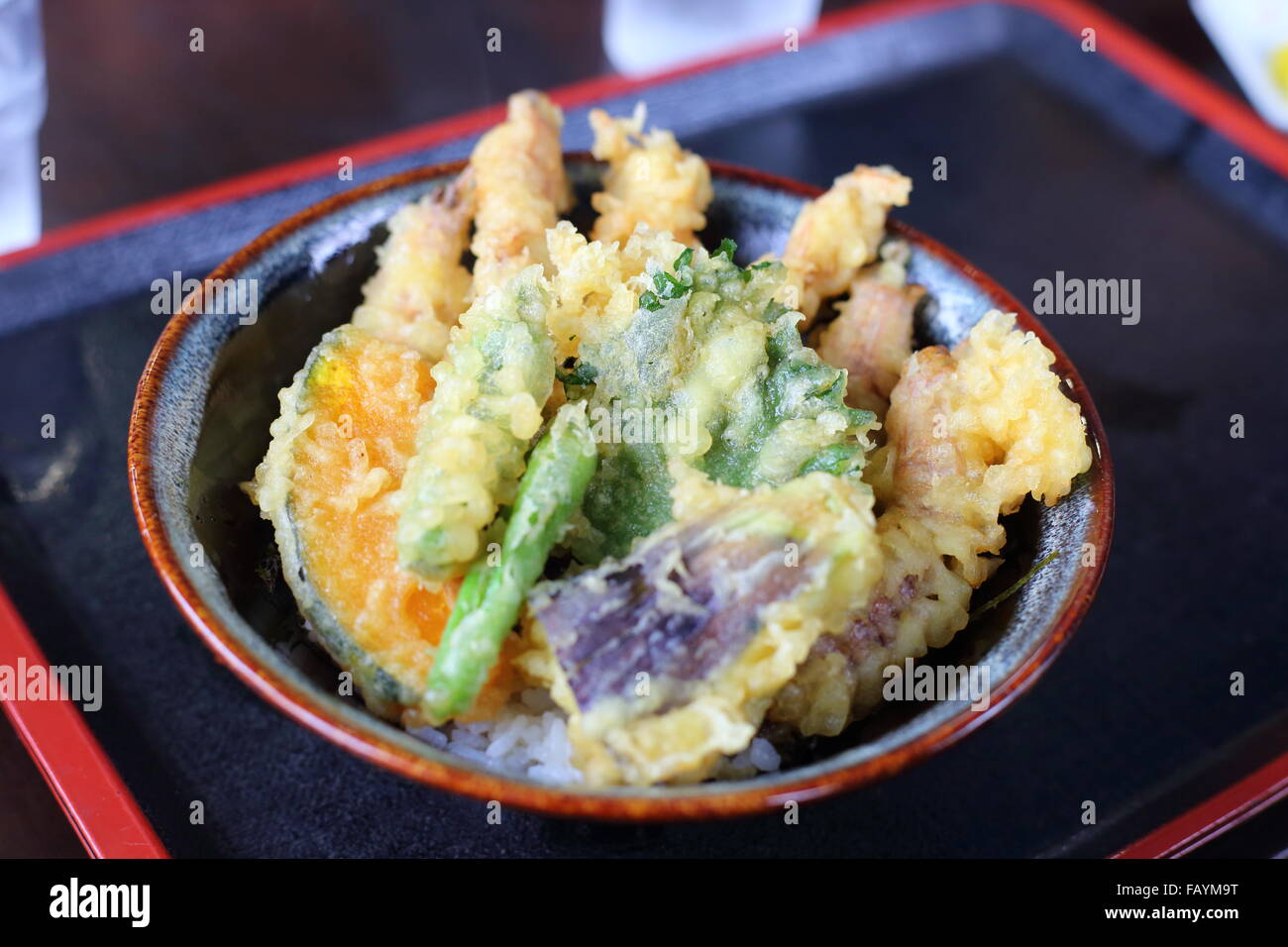 eine Schüssel mit Reis, garniert mit Deep‐fried Fisch und Gemüse Stockfoto