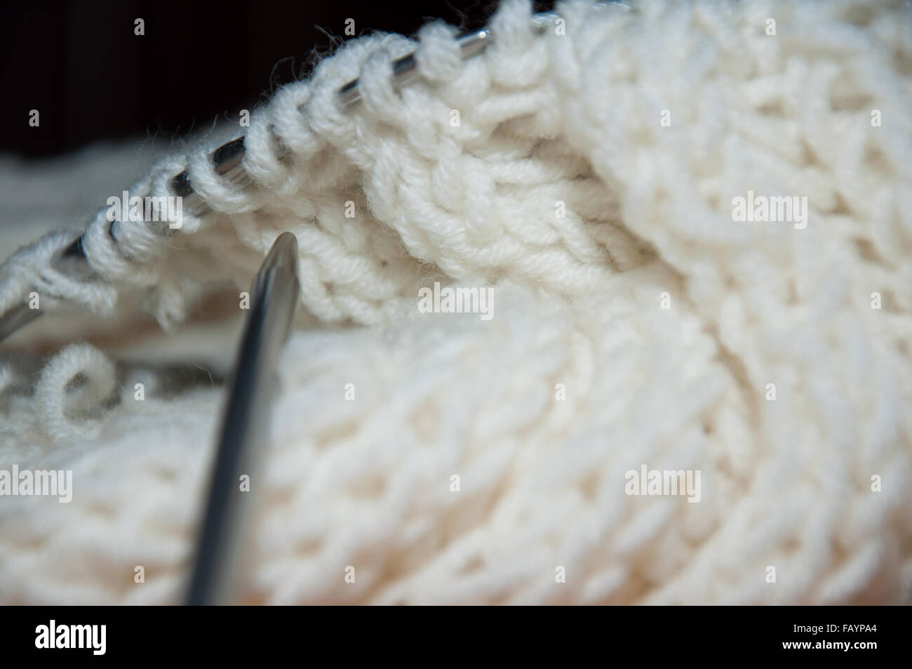 Weiße Wolle Schal und Stricknadel. Stricken Sie Arbeit. Stockfoto