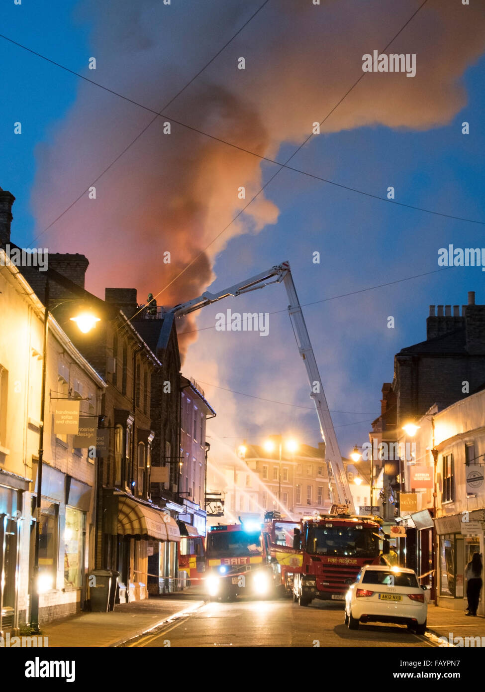 Feuerwehrleute, die Bewältigung einer Flamme am späten Abend in Sudbury, Suffolk, England. Stockfoto