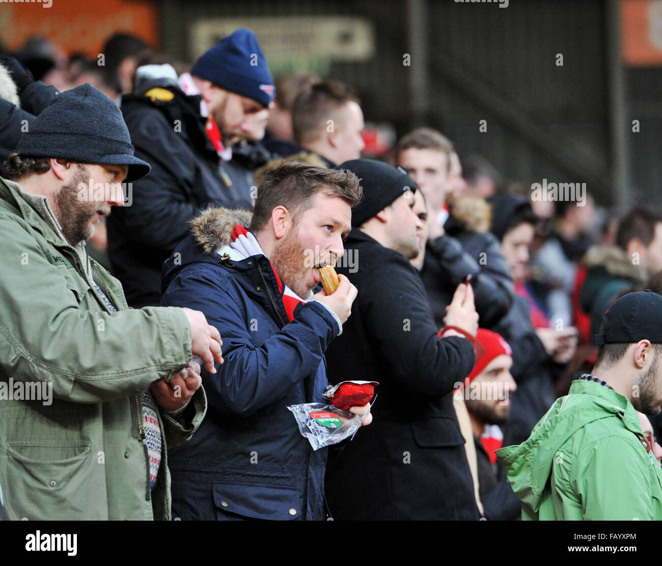 Fußball-Fan Essen eine Torte auf einer Meisterschaft match UK Stockfoto