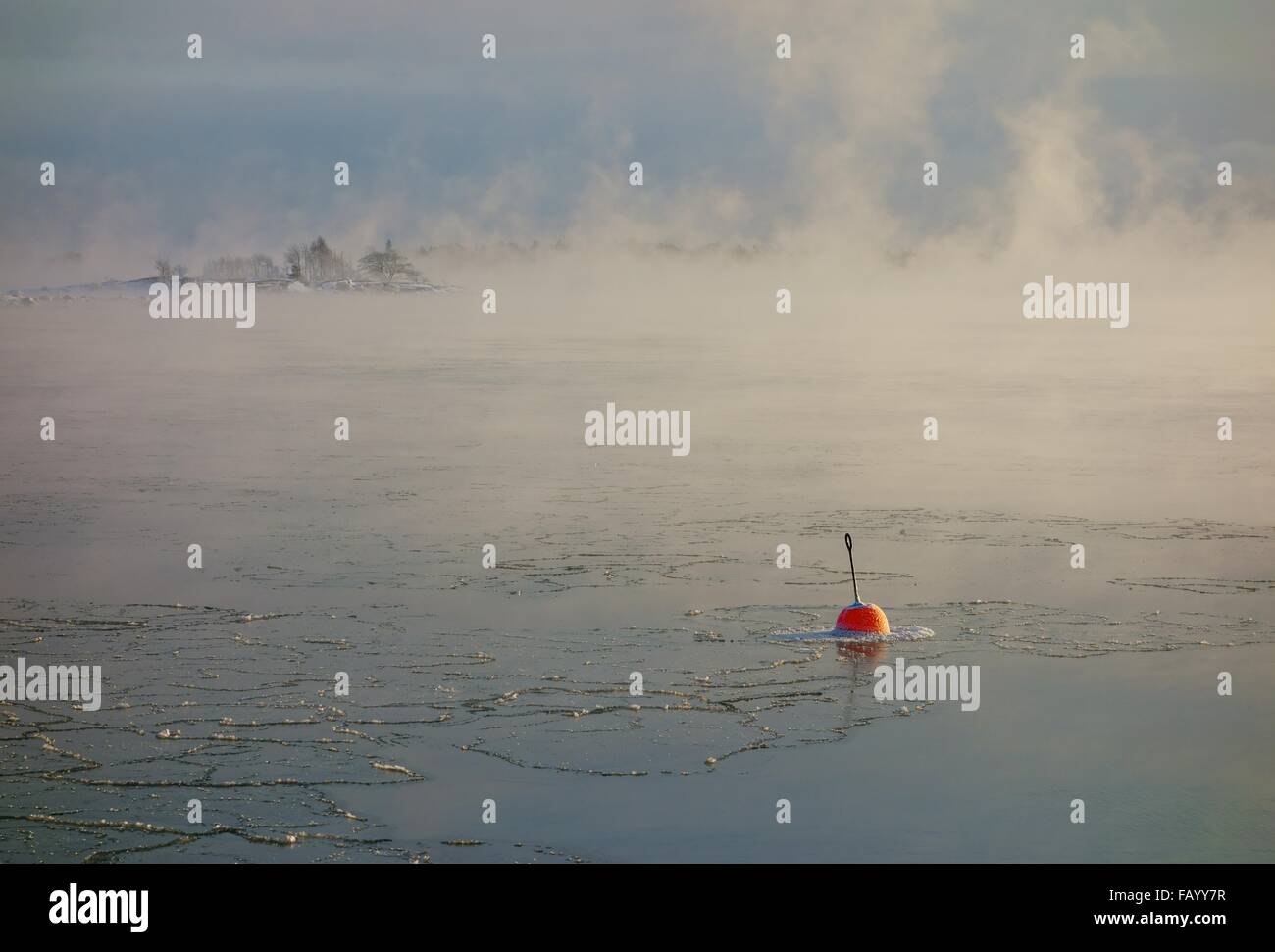 Kleine rote Boje im Wasser, die zu gefrieren in der Ostsee in den Schären von Helsinki, Finnland. Stockfoto