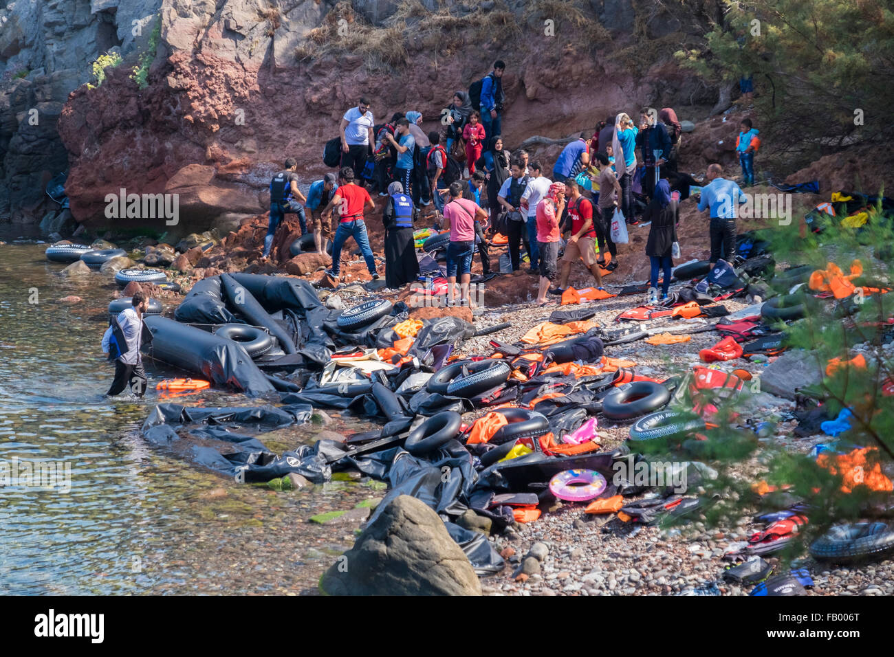 Eine Gruppe afghanischer Flüchtlinge kommen in Lesbos, Griechenland aus der Türkei von Schlauchboot in einer Bucht, gefüllt mit Schutt aus früheren Flöße. Stockfoto