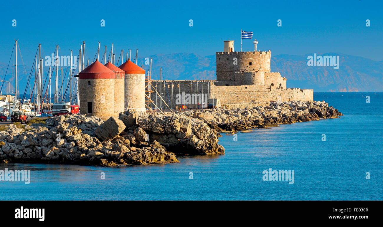 Die Burg und die alten Windmühlen am Eingang zum Hafen von Mandraki in Rhodos, Griechenland Stockfoto