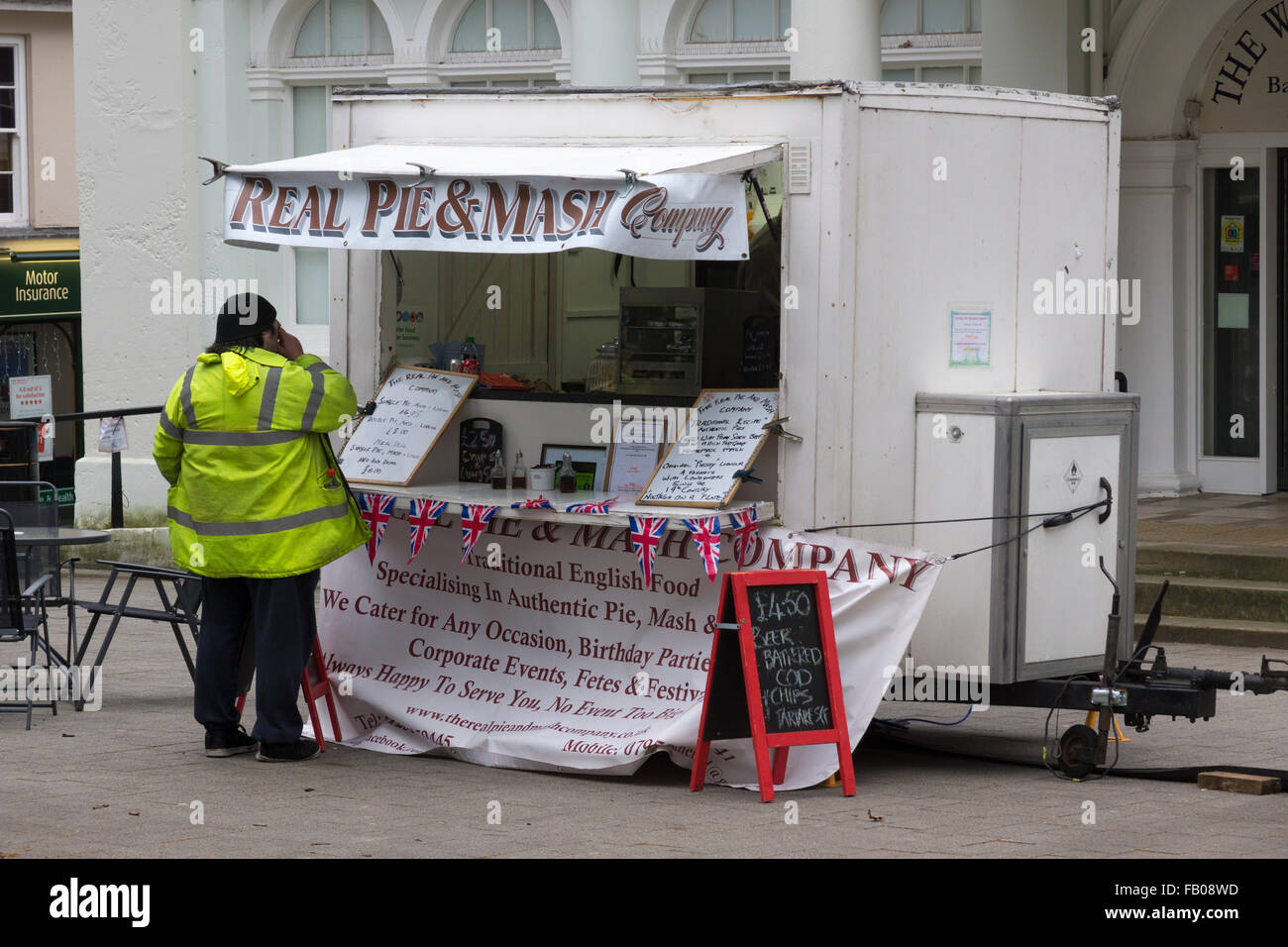 Ein Mann in einem High-Vis-Jacke, Essen bestellen, an einem echten Pie und Mash Unternehmen Stand vor dem Willis Museum in Basingstoke Stockfoto