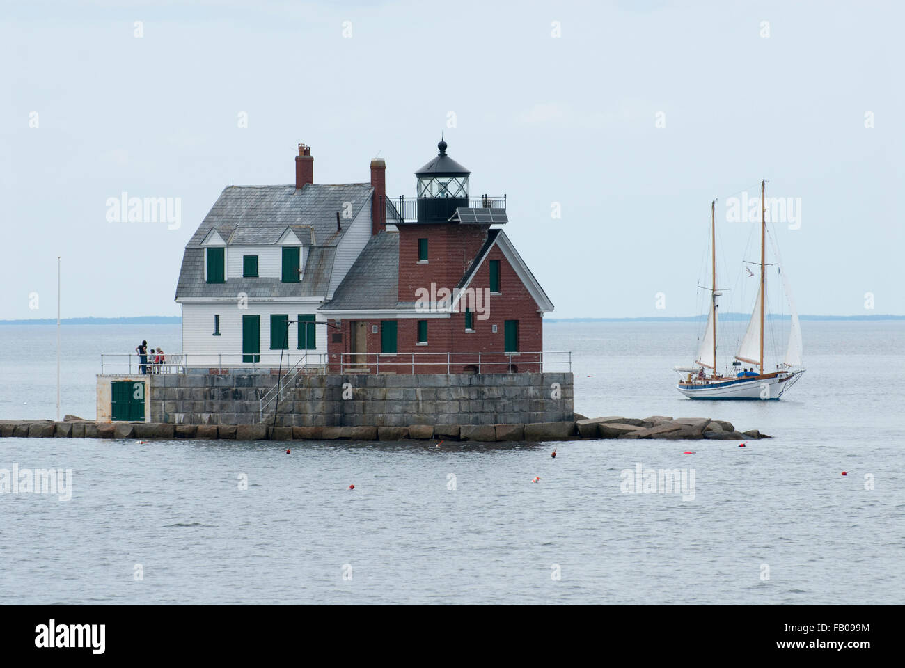 Segelboot vergeht Rockland Breakwater Leuchtturm an einem bewölkten Tag im Sommer mid coast Maine bei Flut. Die Region ist berühmt für Segeltörns. Stockfoto