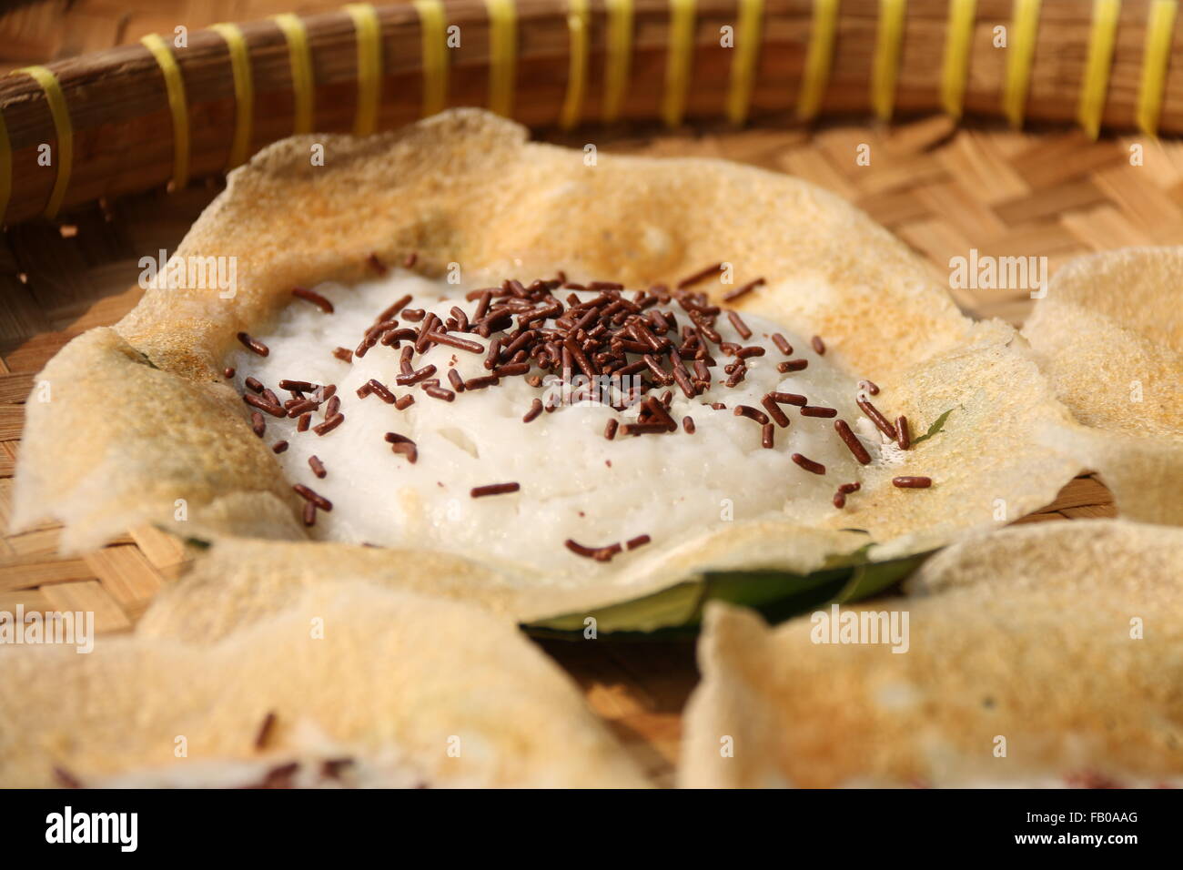 Serabi Solo, Pfannkuchen Kokosmilch von Solo, mit Schokostreuseln hinzugefügt. Auf traditionellen geflochtenem Bambus Tablett gelegt. Stockfoto
