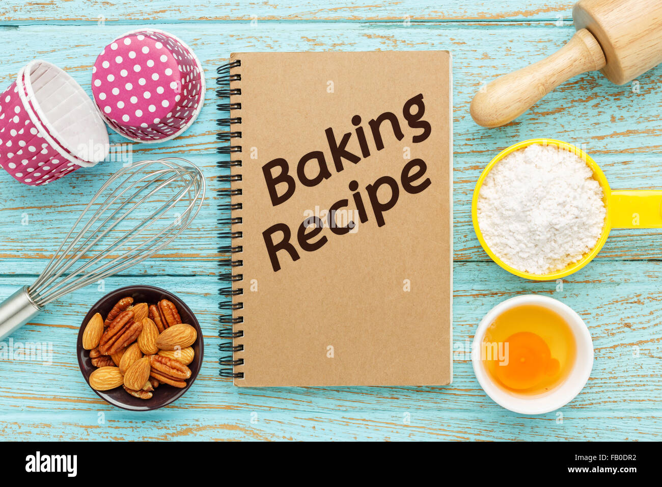 Backen Rezeptbuch mit Backzutaten auf Holztisch Stockfoto