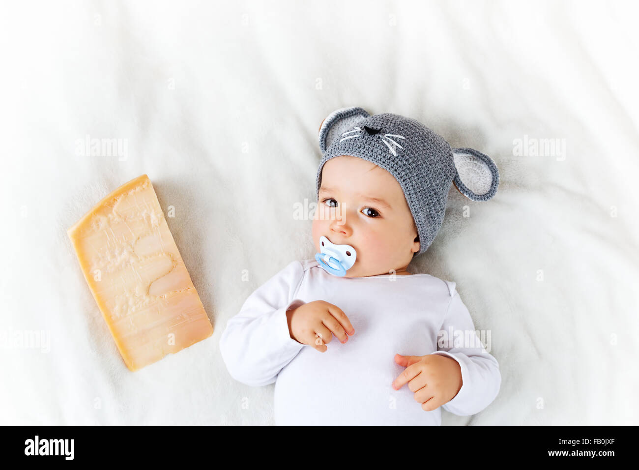 Baby Boy in Maus Hut auf Decke liegend mit Käse Stockfoto