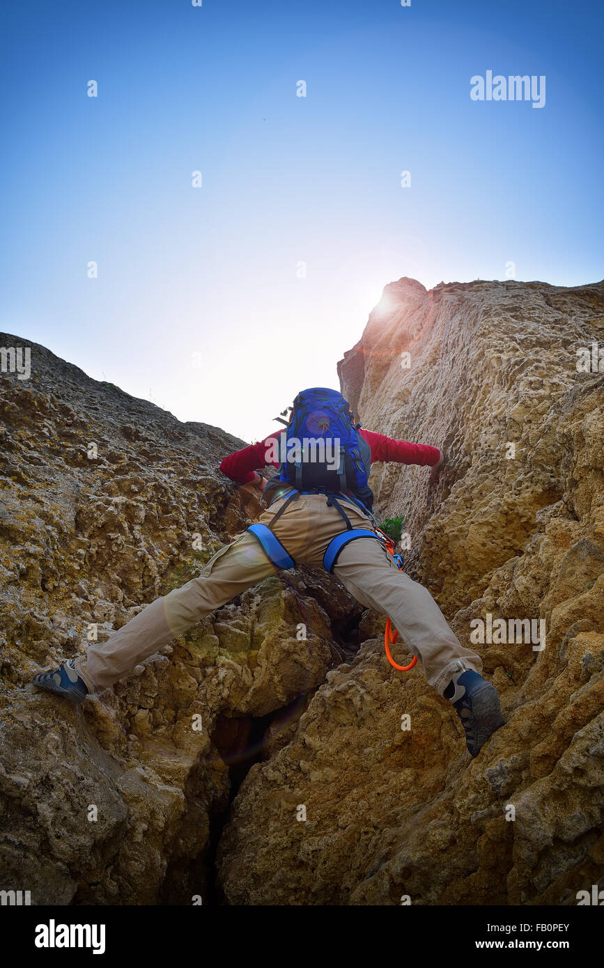 Kletterer mit Rucksack Klettern auf einer Klippe Stockfoto