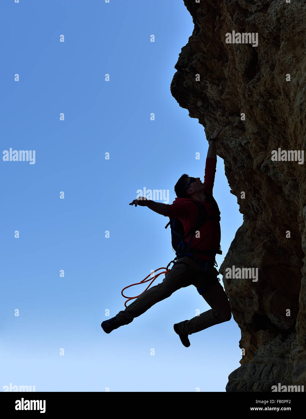 junge Bergsteiger mit Rucksack fiel von einer Klippe Stockfoto