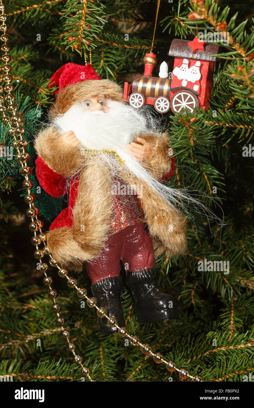 Traditioneller Weihnachtsbaum mit Weihnachtsmann und hängenden hölzernen Weihnachtsdekorationen Stockfoto