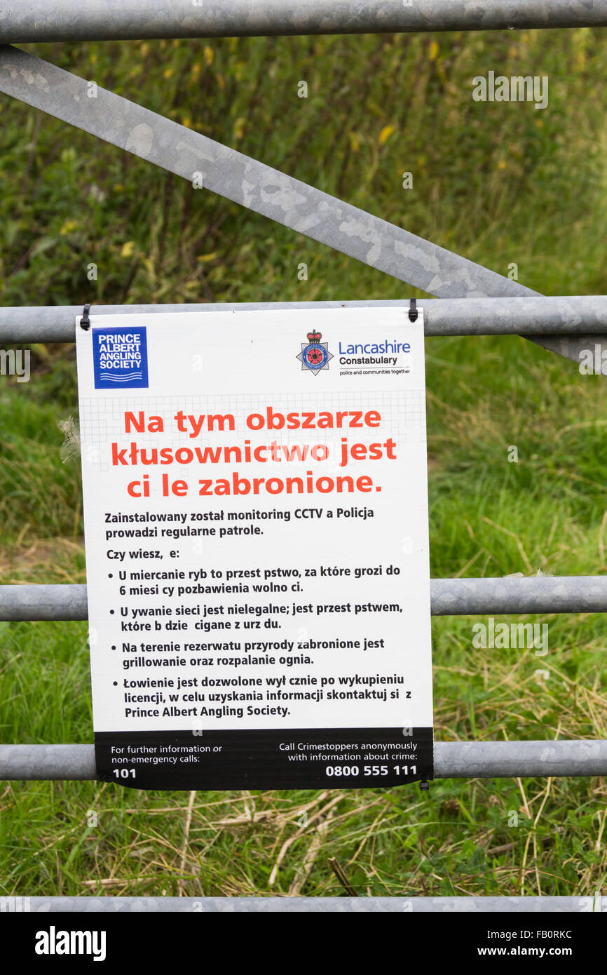 Polnische Sprache Warnzeichen in der Nähe von dem Fluss Ribble nahe Preston, Lancashire warnt vor Einnahme und Süßwasser Fisch zu essen. Stockfoto