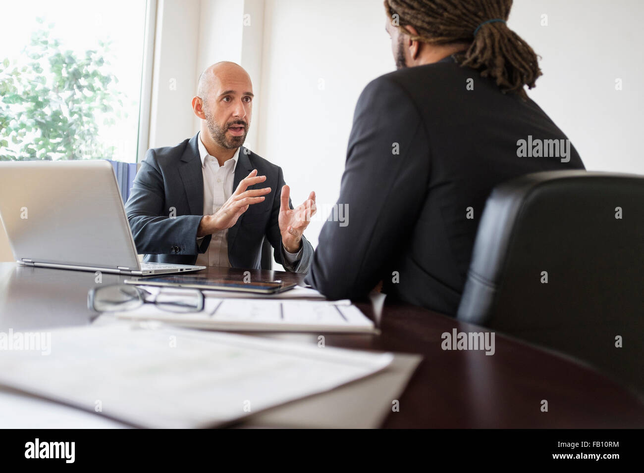 Zwei Geschäftsleute mit Diskussion am Schreibtisch im Büro Stockfoto