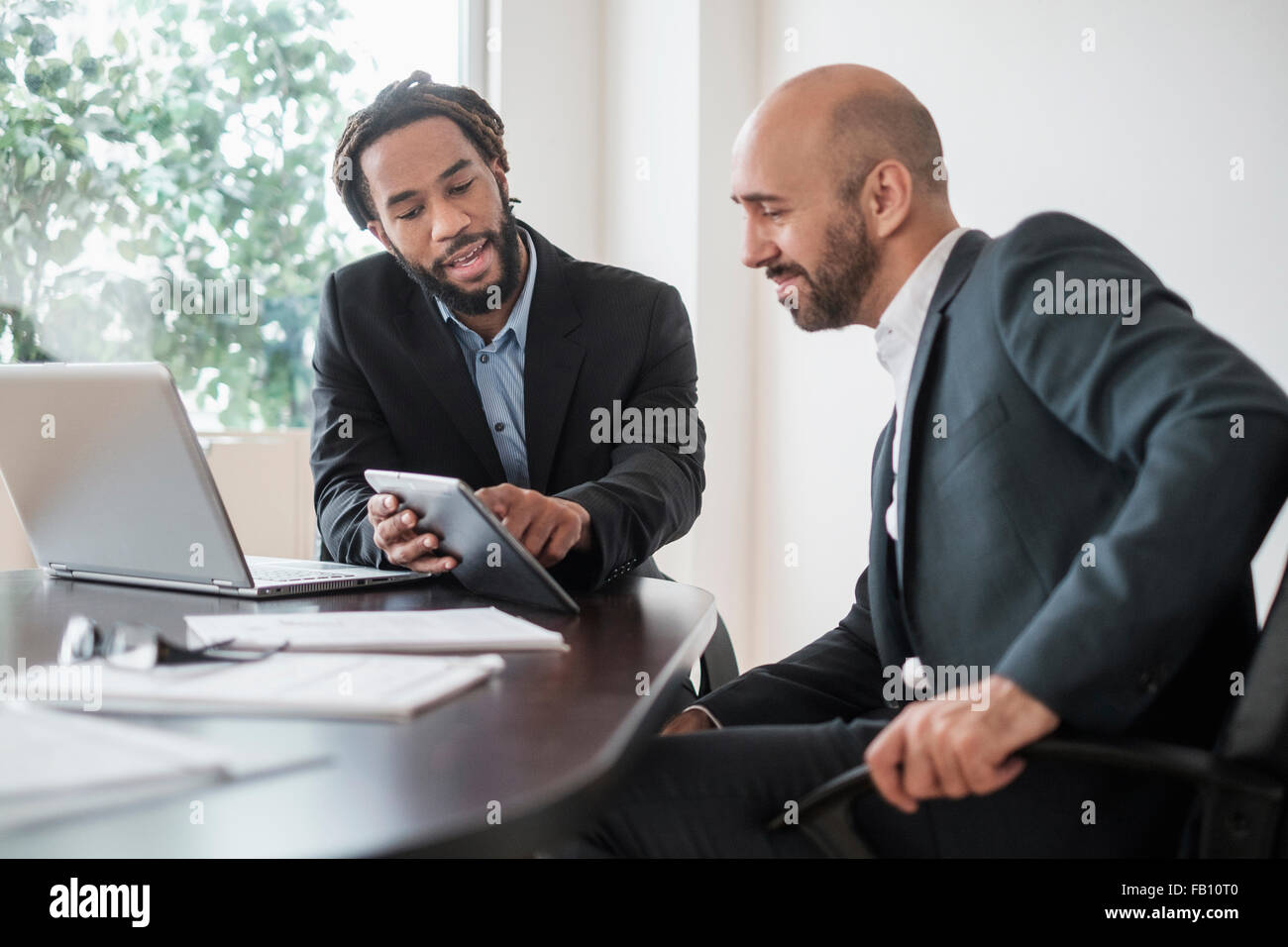 Zwei Geschäftsleute arbeiten mit digitalen Tablet vom Schreibtisch im Büro Stockfoto