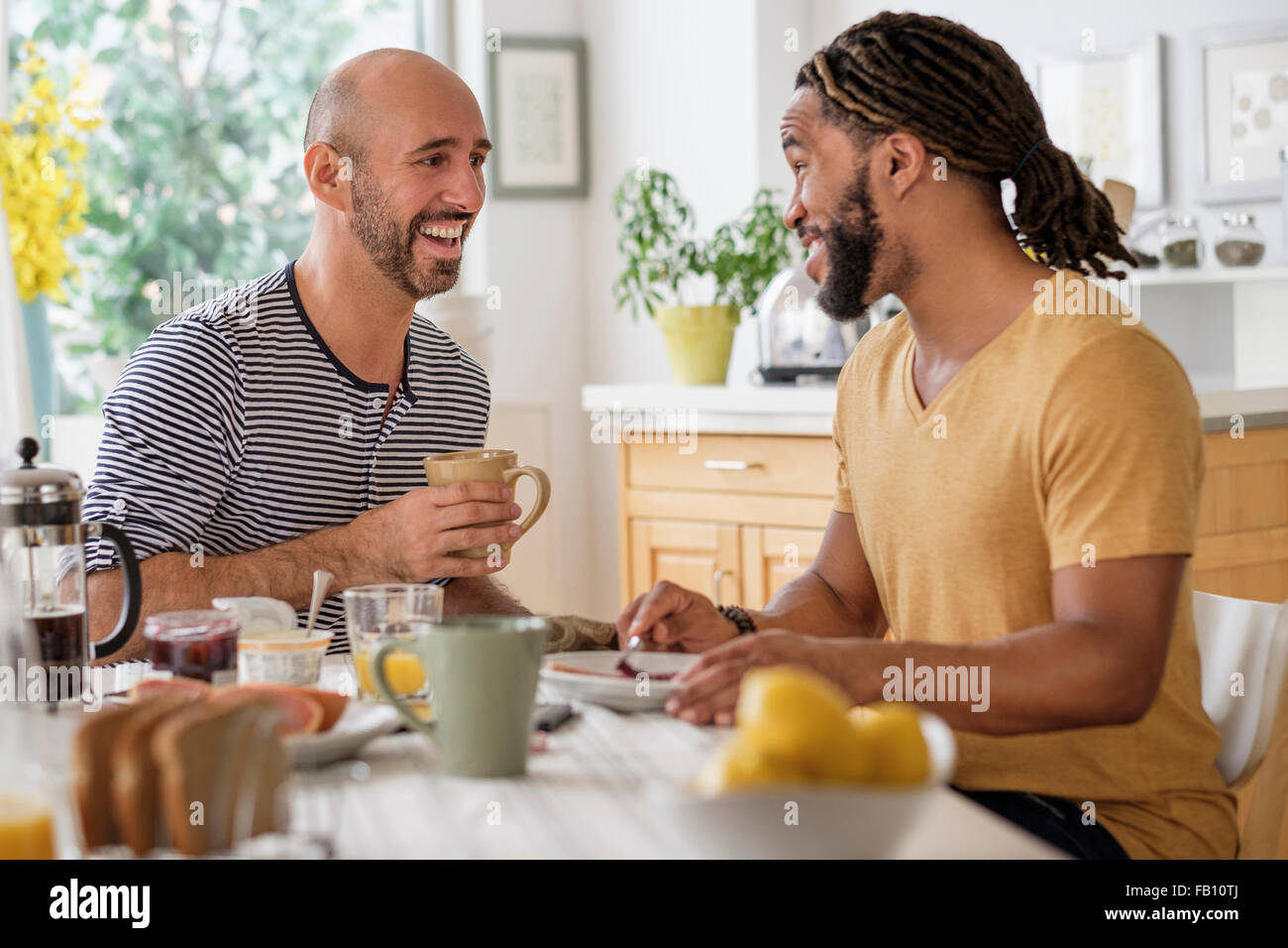 Smiley homosexuelles Paar frühstücken in Küche Stockfoto