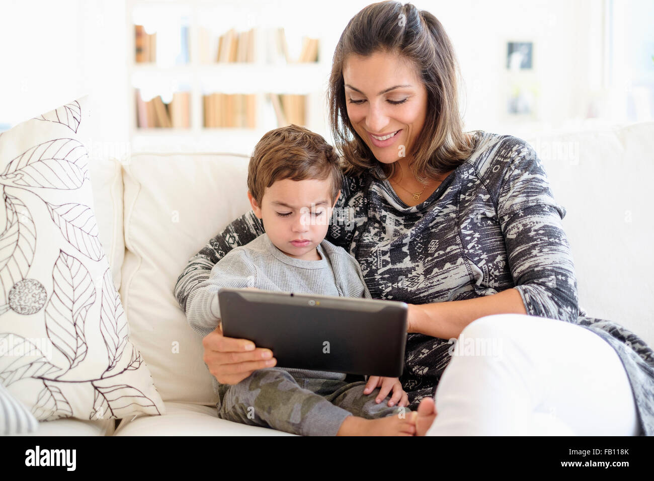 Mutter mit Sohn am Sofa (2-3) lesen Stockfoto