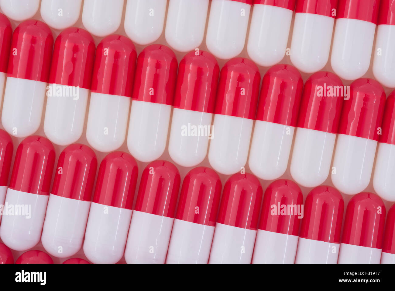 Nahaufnahme der Pillen - Kapselform aus Gelatine. Rote / weiße Pillen. Metapher, die amerikanische Drogenunternehmen über hohe Drogenpreise, Drogenstudien. Stockfoto