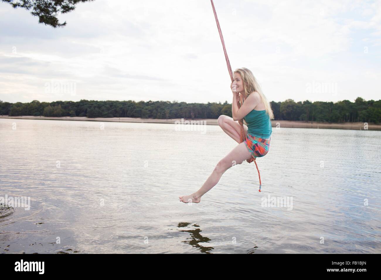 Junge Frau Seil schwingen über See Stockfotografie - Alamy