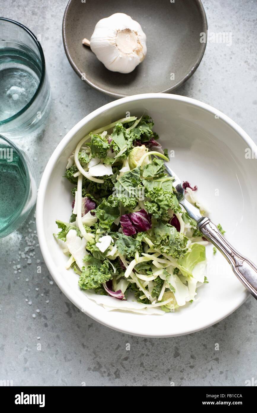 Draufsicht auf Salatblätter und Knoblauchzwiebel in Schalen Stockfoto