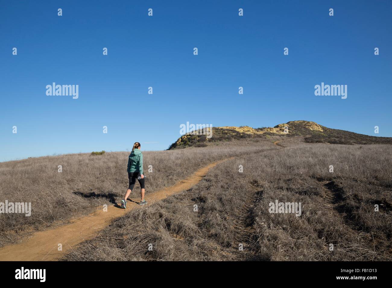 Weibliche Läufer bewegt sich Hügel Weg Stockfoto