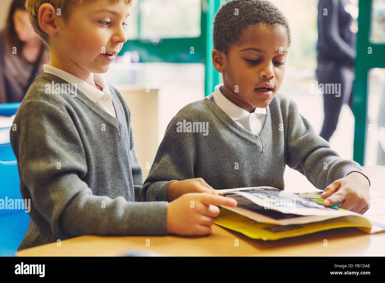 Zwei jungen tun lesen Bilderbuch am Schreibtisch im Klassenzimmer der Grundschule Stockfoto
