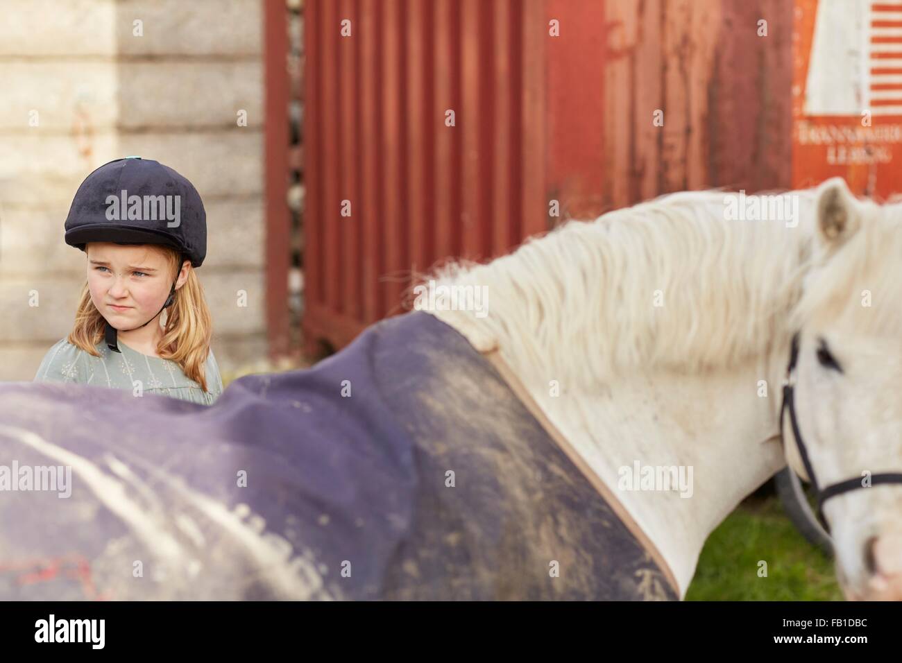 Mädchen und Pony Blick über ihre Schulter am Stall Stockfoto