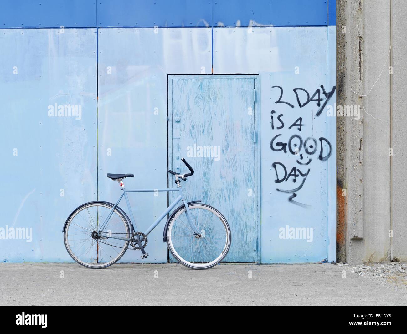 Fahrrad gegen Graffitiwand geparkt Stockfoto