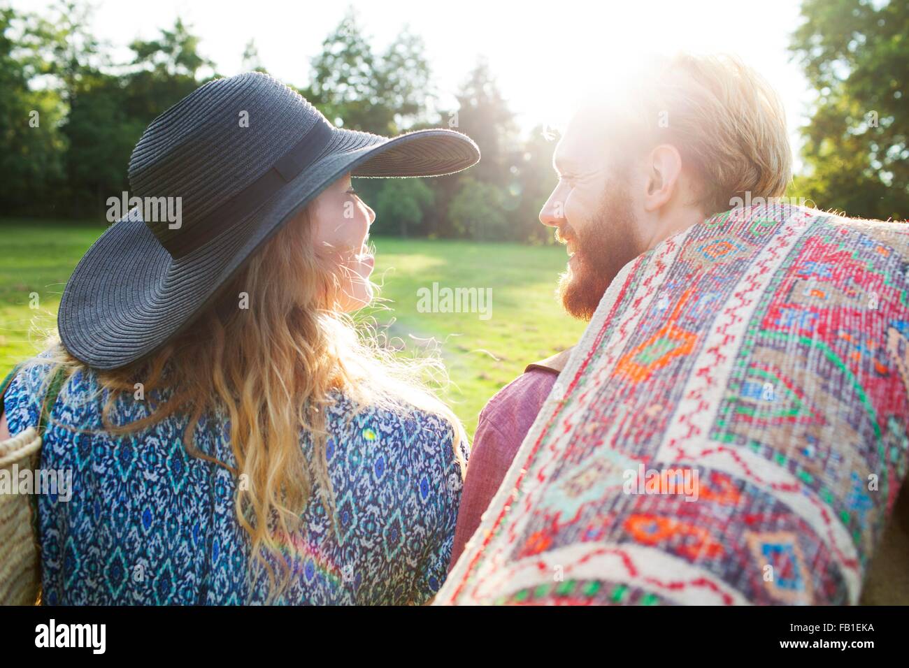 Rückansicht des romantischen jungen Paares tragen Teppich für Picknick im park Stockfoto