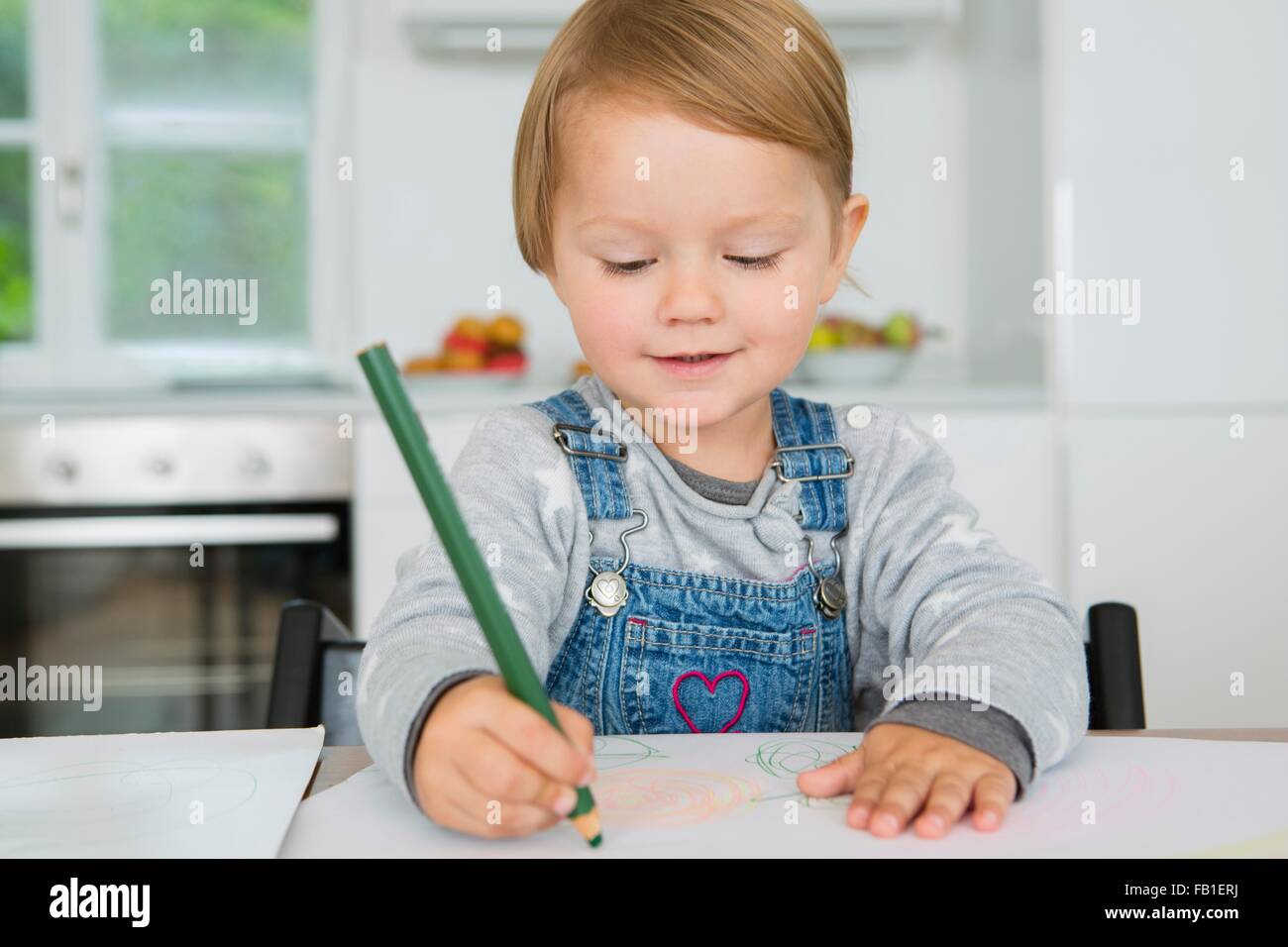Weiblichen Kleinkind Zeichnung am Küchentisch Stockfoto