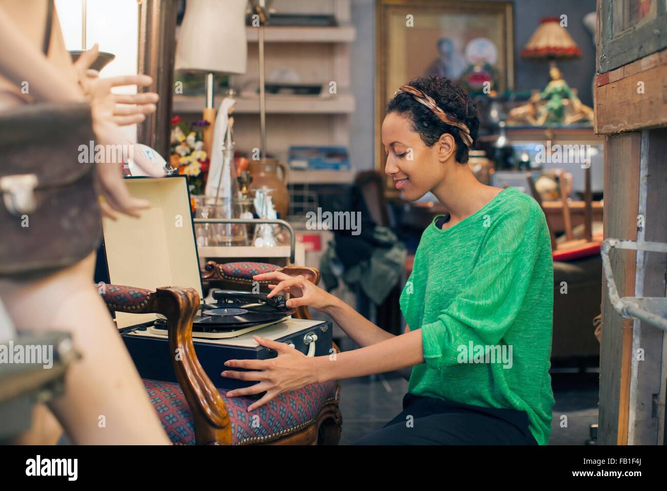 Junge Frau spielt Schallplatten in Vintage-shop Stockfoto