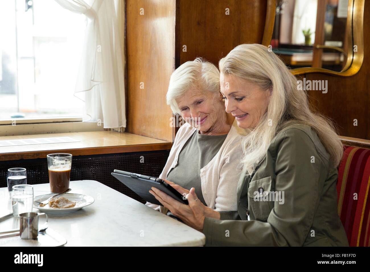 Mutter und Tochter beisammen sitzen im Café, Blick auf digital-Tablette Stockfoto