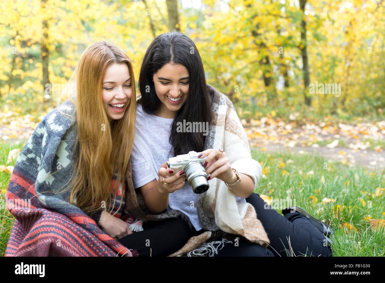 Junge Frauen Lächeln in die Kamera im Wald, Hampstead Heath, London Stockfoto