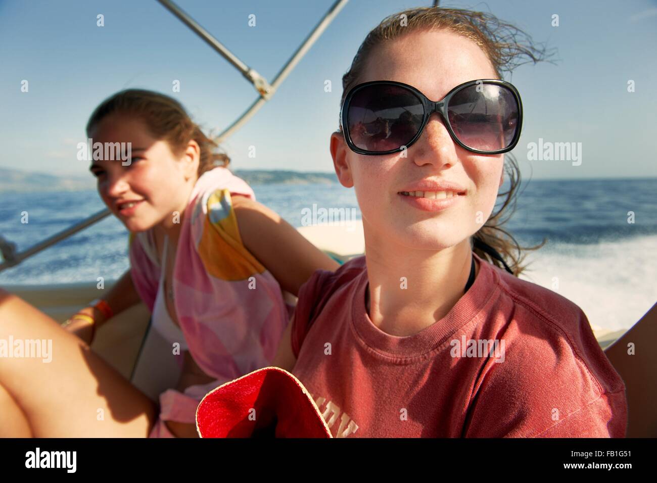 Zwei Mädchen im Teenageralter auf Boot auf hoher See Stockfoto
