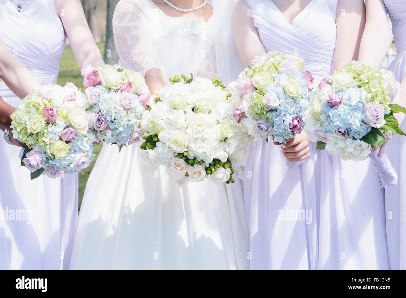 Blick auf Braut und Brautjungfern nebeneinander halten Blumensträuße beschnitten Stockfoto