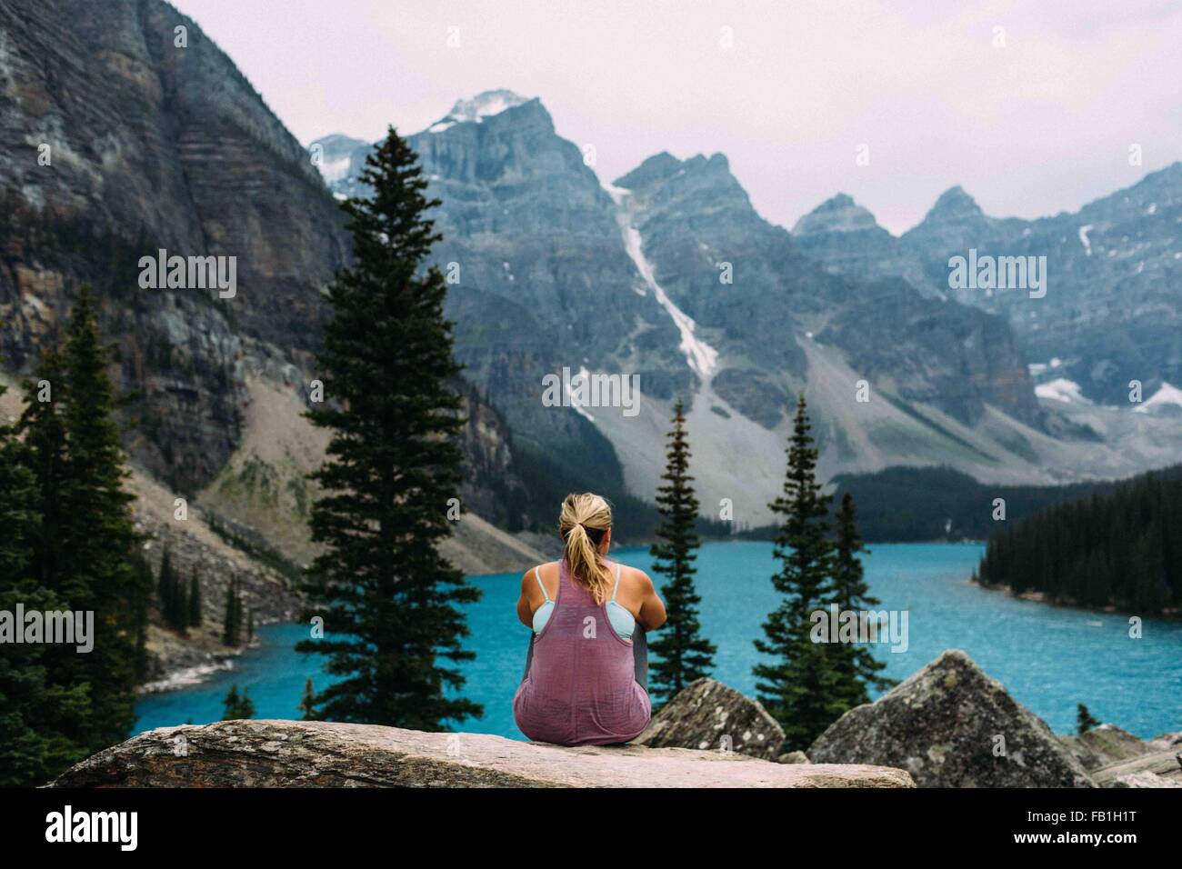 Rückansicht der Mitte Erwachsene Frau auf Klippe erhöhten betrachten der Moraine Lake, Banff Nationalpark, Alberta Kanada Stockfoto