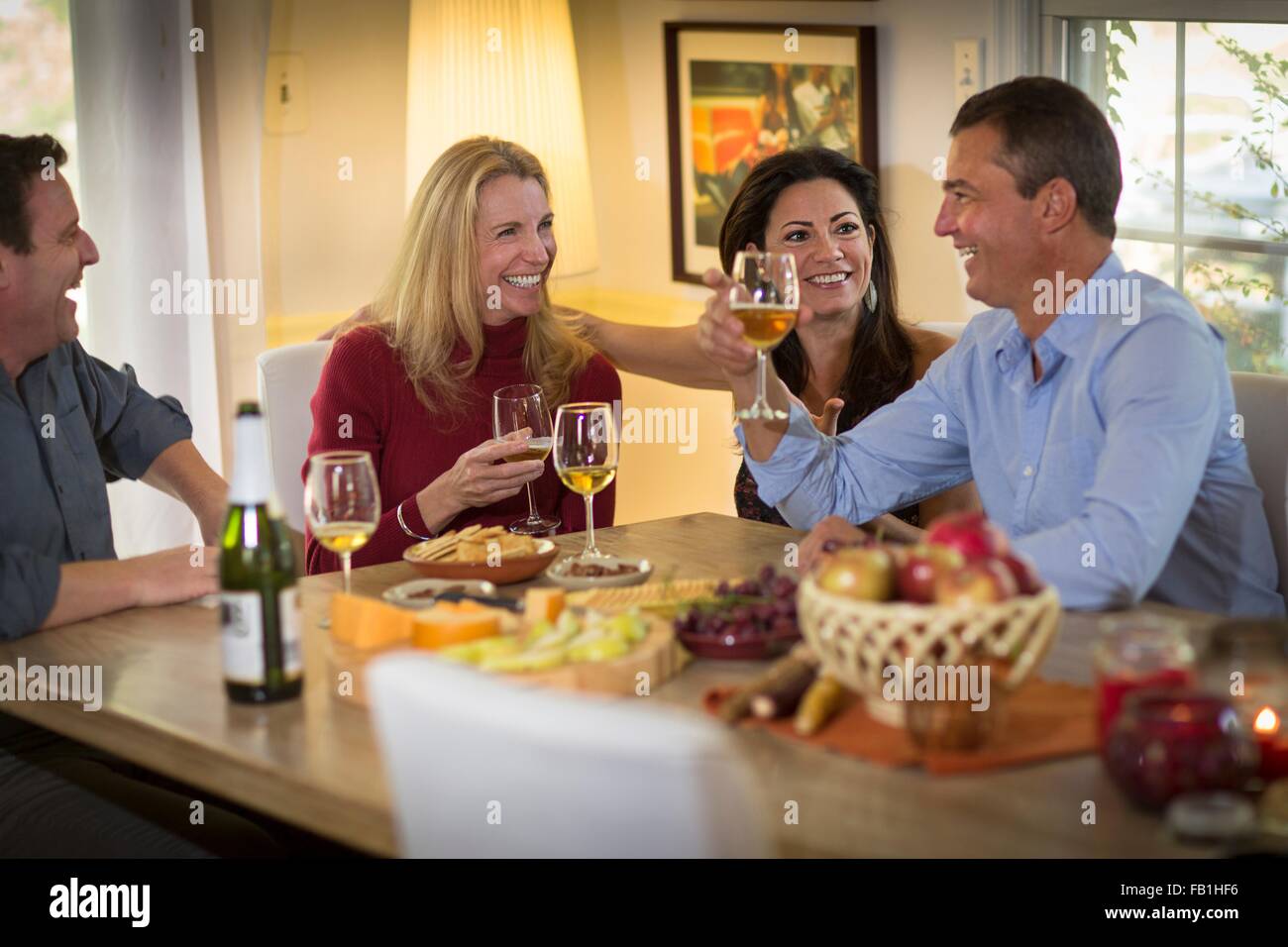 Zwei ältere Ehepaare, Wein trinken und plaudern bei Dinner-party Stockfoto