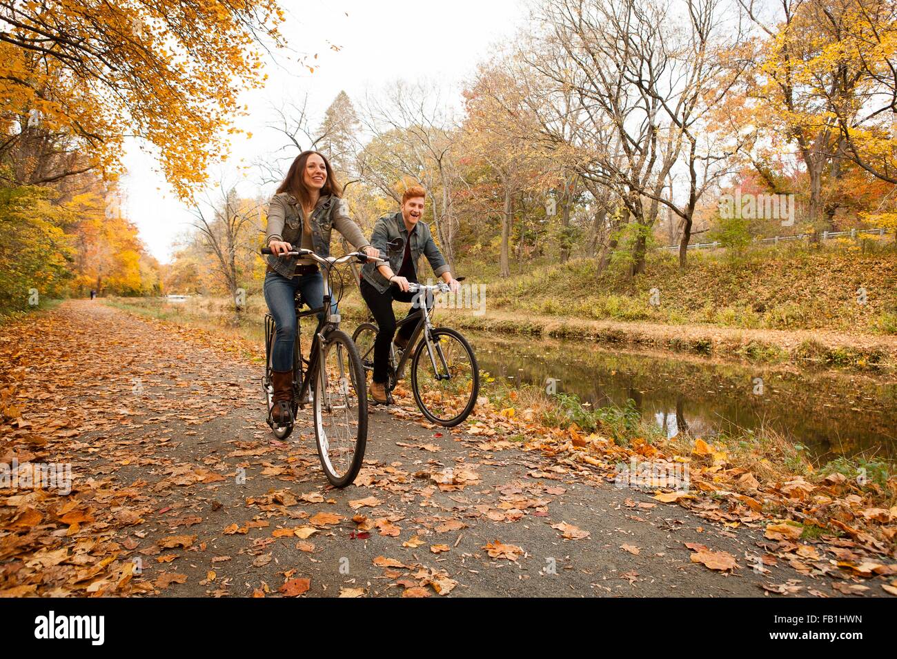 Glückliches junges Paar Radtouren entlang der Flussufer im Herbst Stockfoto