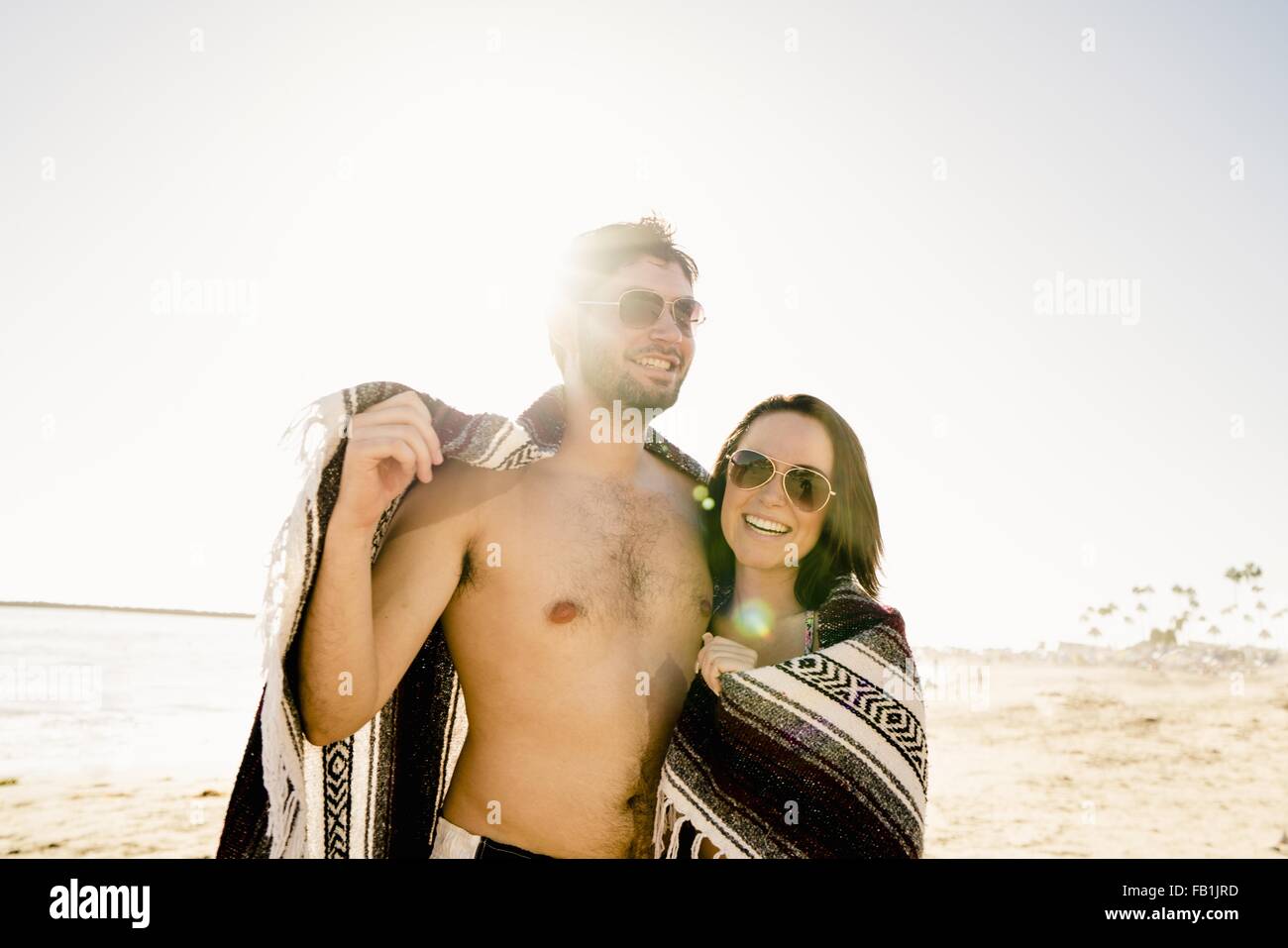 Porträt des jungen Paares eingewickelt in Decke auf Newport Beach, Kalifornien, USA Stockfoto