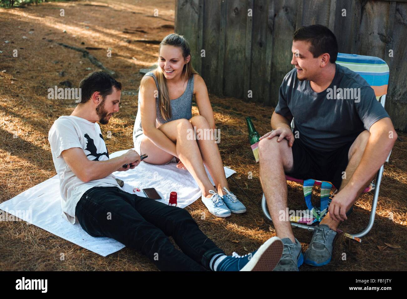 Drei Erwachsenen Freunden entspannende außerhalb der Hütte im Wald Stockfoto
