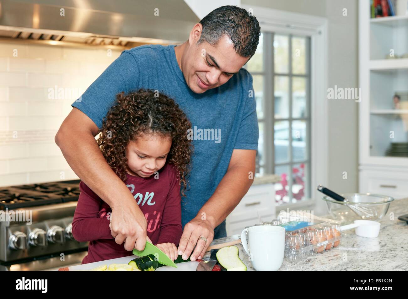 Vater Tochter Hacken Gemüse in der Küche zu helfen Stockfoto