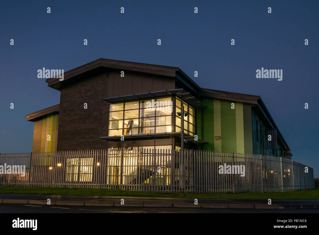 Gewerbeimmobilien Industrieanlage Exterieur genommen in der Abenddämmerung, UK. Schaufensterpuppe im Fenster. Stockfoto