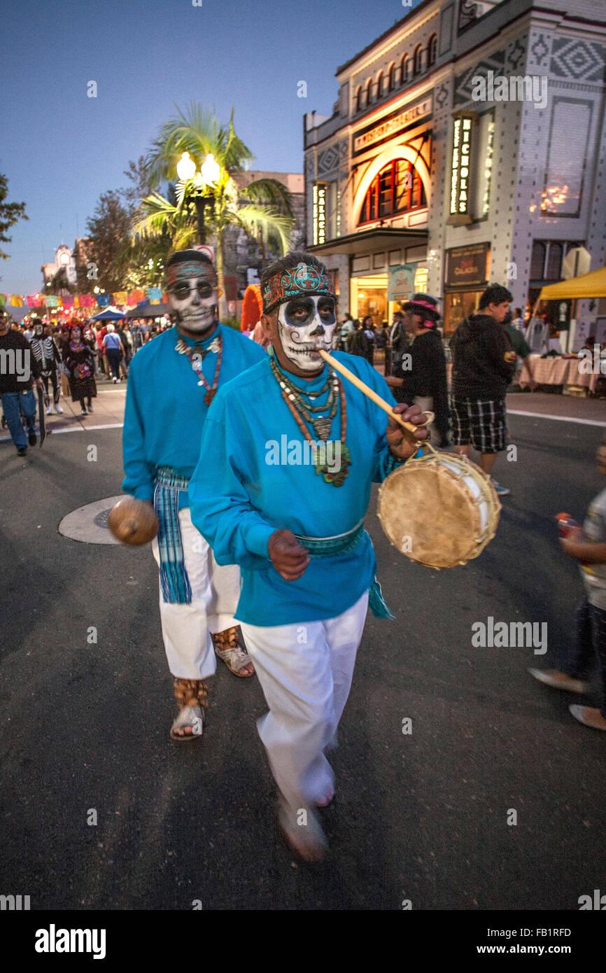 Geschminkt wie das Gesicht von La Calavera Catrina ("Dapper Skelett"), Straßenkünstler, die mit Trommeln und Flöten gehen die Straße während des Tages der Toten oder Dia de Muertos Urlaub unter Hispanics in Santa Ana, Kalifornien. Der Urlaub im Mittelpunkt Servi Stockfoto