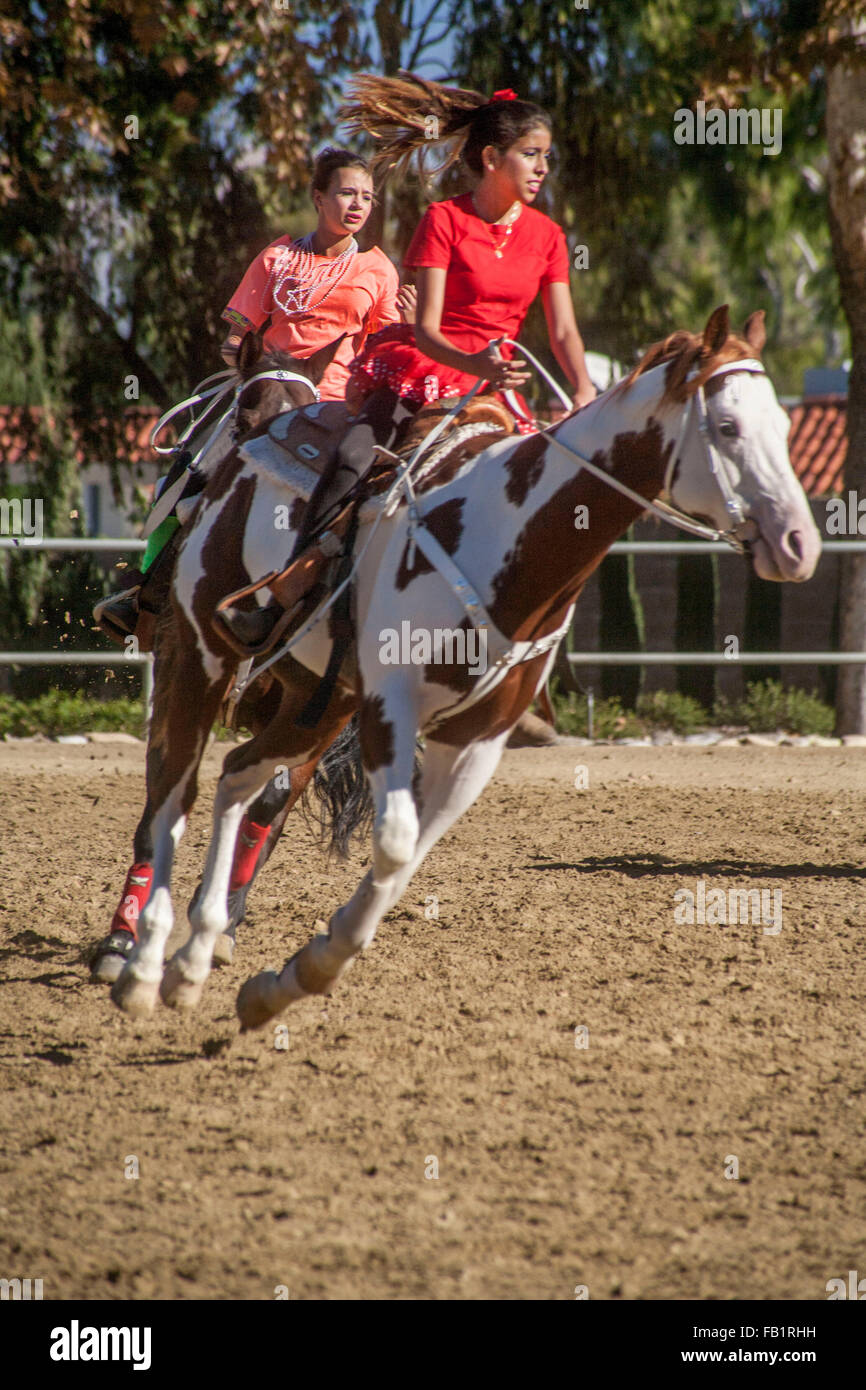 Hispanische junge Erwachsene Frauen reiten ihre Pferde im vollen Galopp auf einem Reiter treffen sich in Laguna Woods, CA. Stockfoto