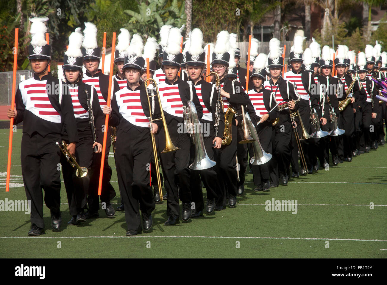 In voller Uniform und mit ihren Instrumenten nimmt eine multirassische High School marschierendes Band das Feld bei einem countywide Bandwettbewerb in Mission Viejo, Kalifornien. Stockfoto