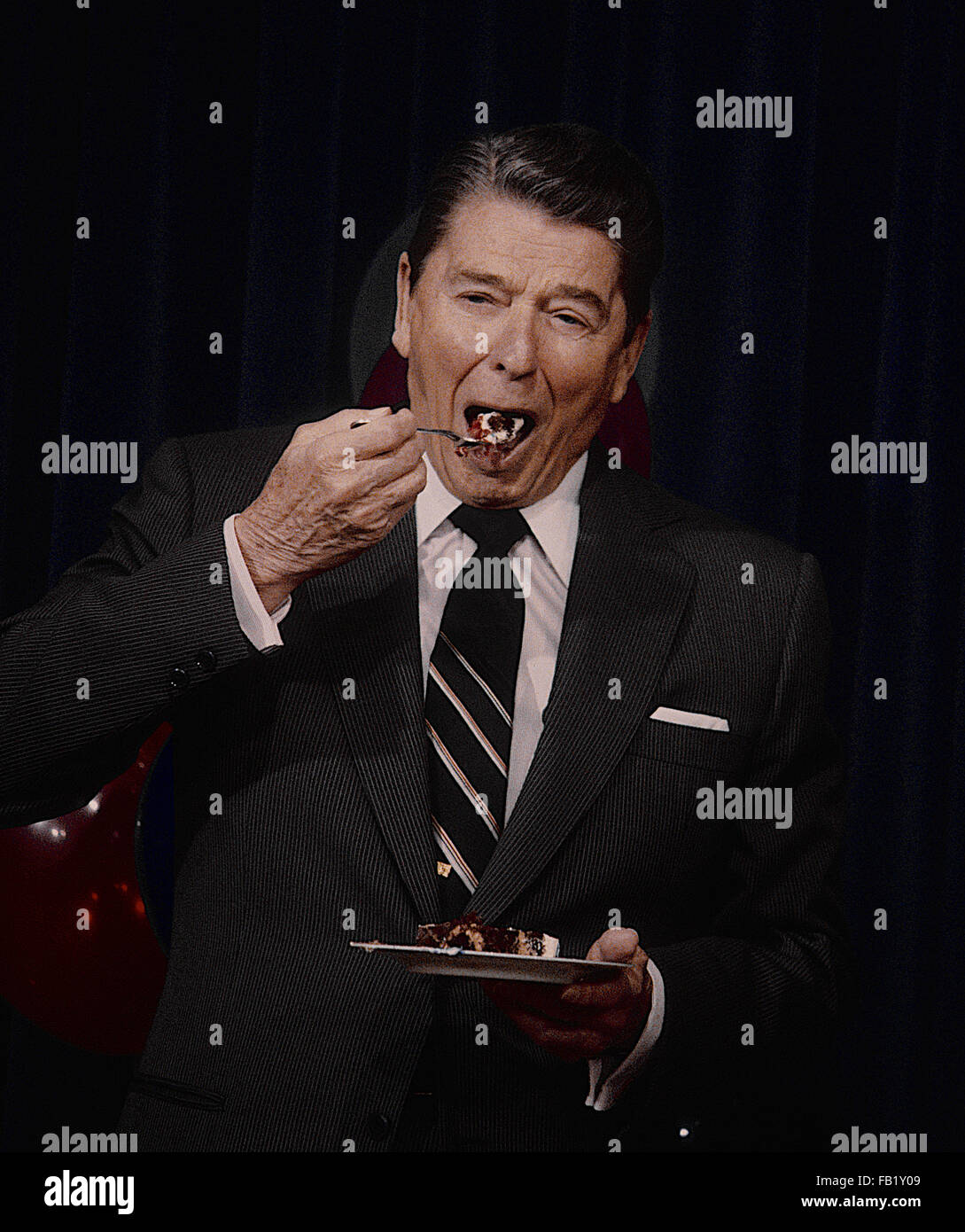 Washington, DC, USA, 6. Februar 1987 Präsident Ronald Reagan feiert seinen Geburtstag im Zimmer 450 OEOB. Genießt ein Stück Kuchen.  Bildnachweis: Mark Reinstein Stockfoto