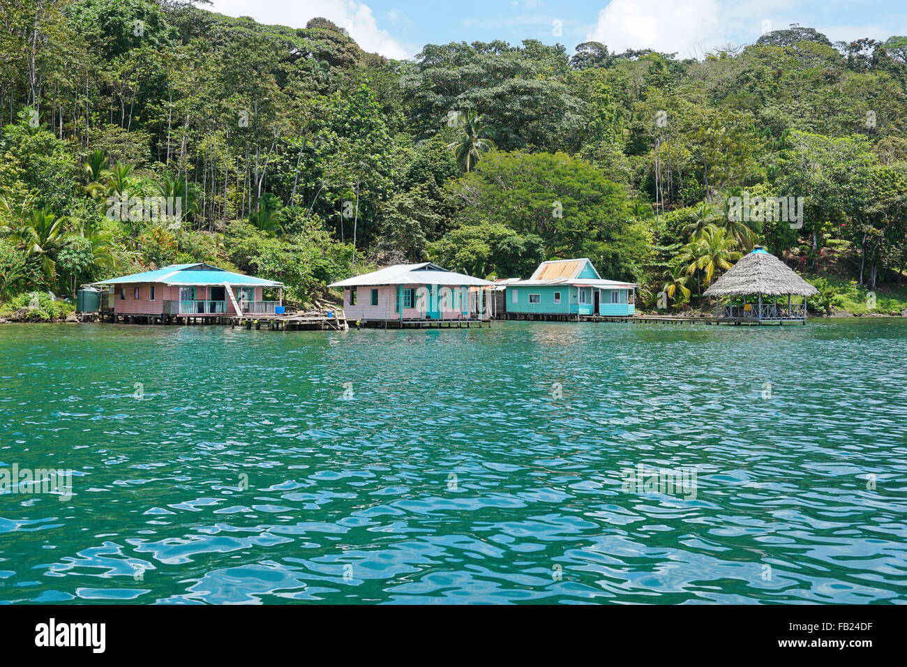 Üppige tropische Küste mit rustikalen Häusern über dem Meer, Bocas del Toro, karibische Küste von Panama in Mittelamerika Stockfoto