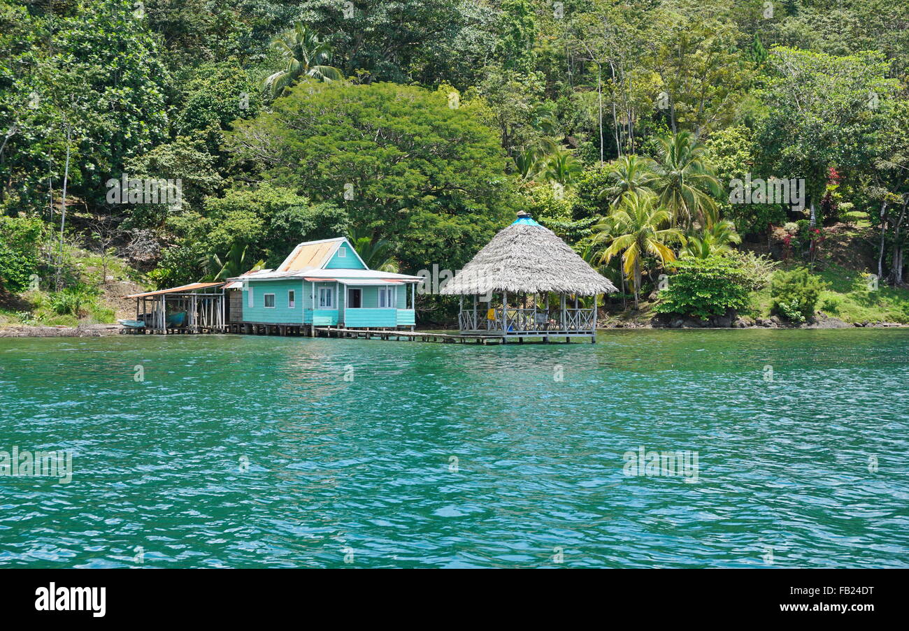 Typisches Landhaus mit strohgedeckten Hütte über dem Wasser in Bocas del Toro, Loma Partida Island, Karibik Küste von Panama Stockfoto