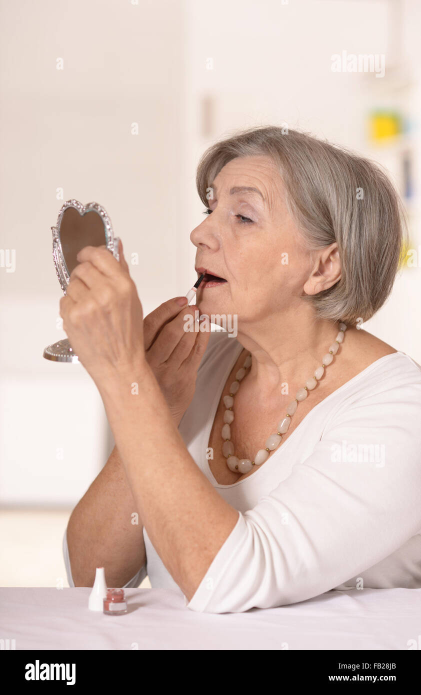 ältere Frau zu Hause in den Spiegel zu schauen Stockfoto