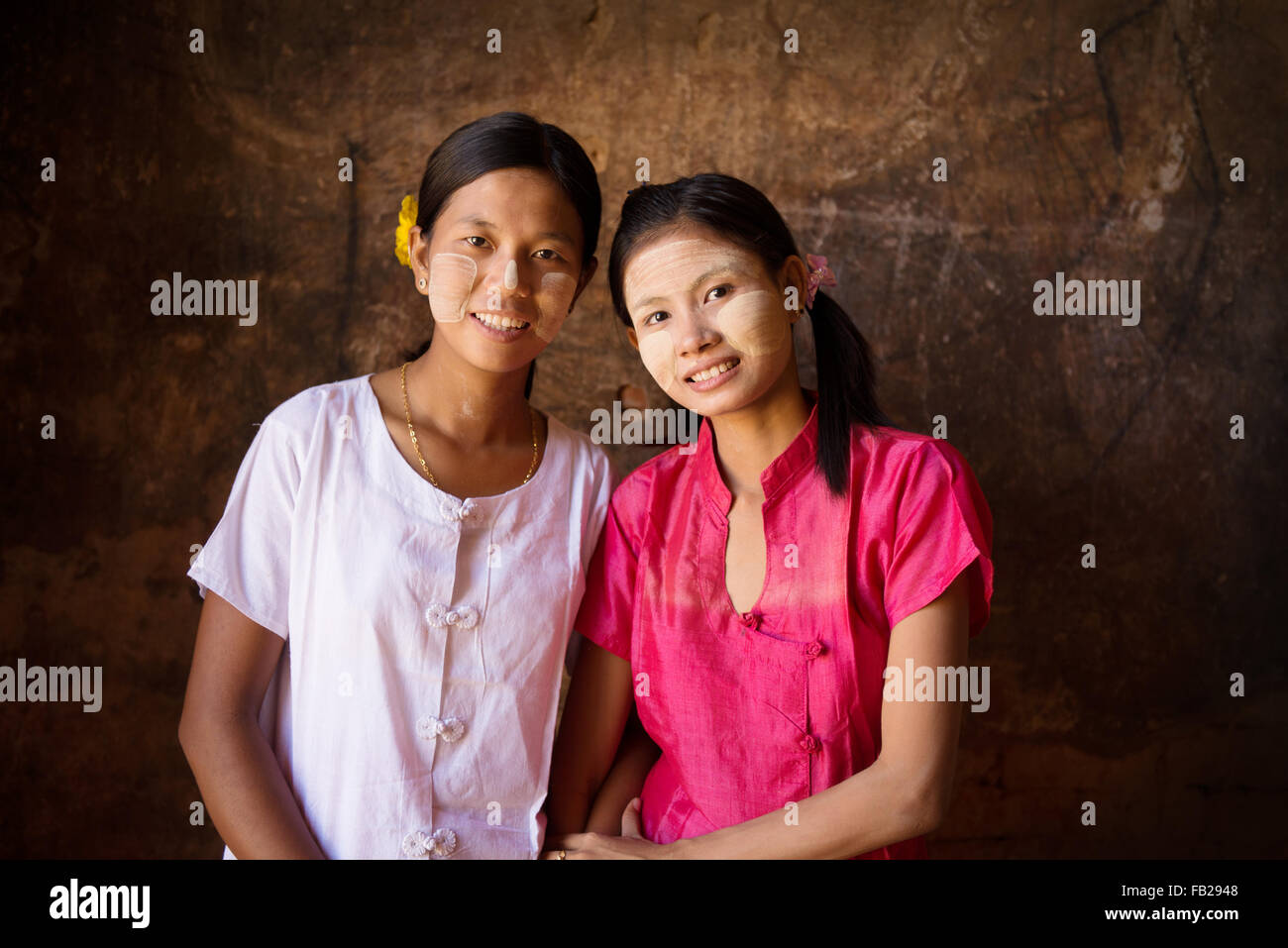 Porträt von zwei schönen Myanmar Mädchen lächelnd, schwachem Licht im Inneren eines Tempels. Stockfoto