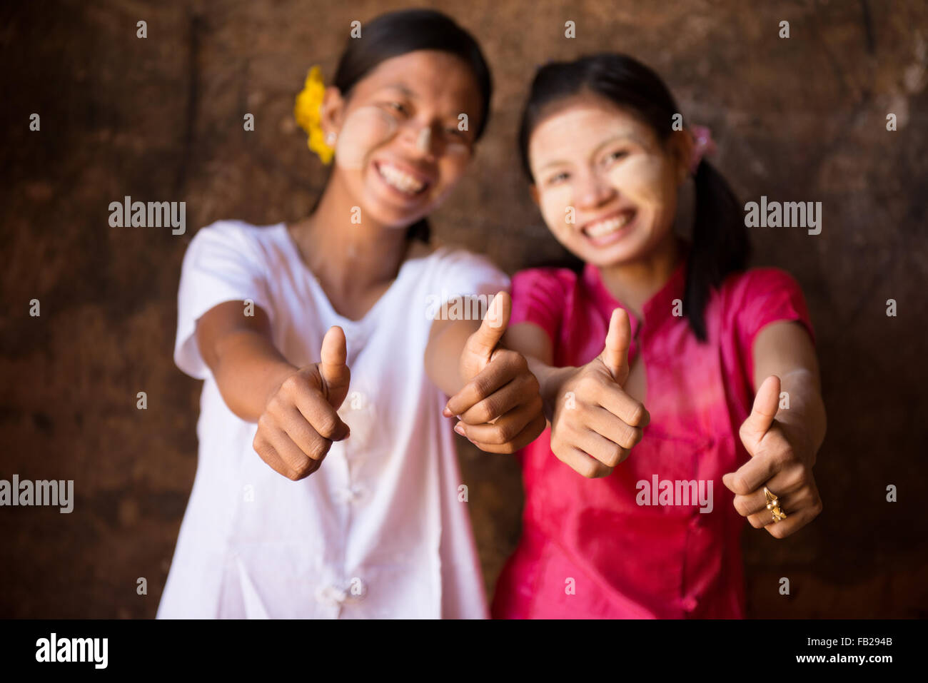Porträt von zwei schönen Myanmar Mädchen lächelnd und Daumen aufgeben. Stockfoto